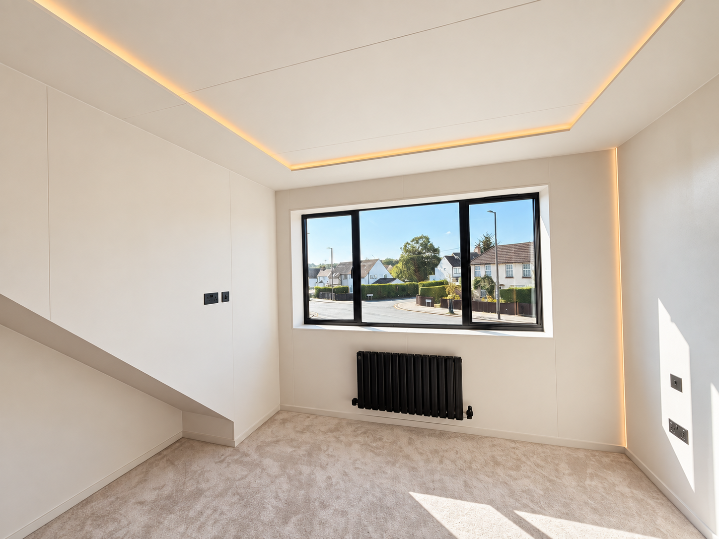 Carpeted bedroom with cove lighting and wide black framed window