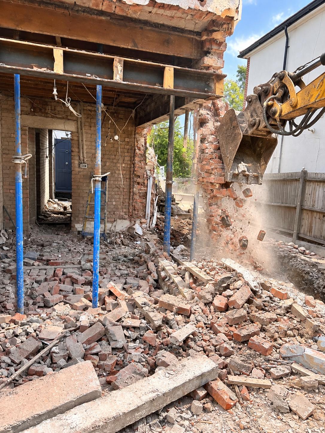 Rear wall being demolished with acrow props supporting the structure