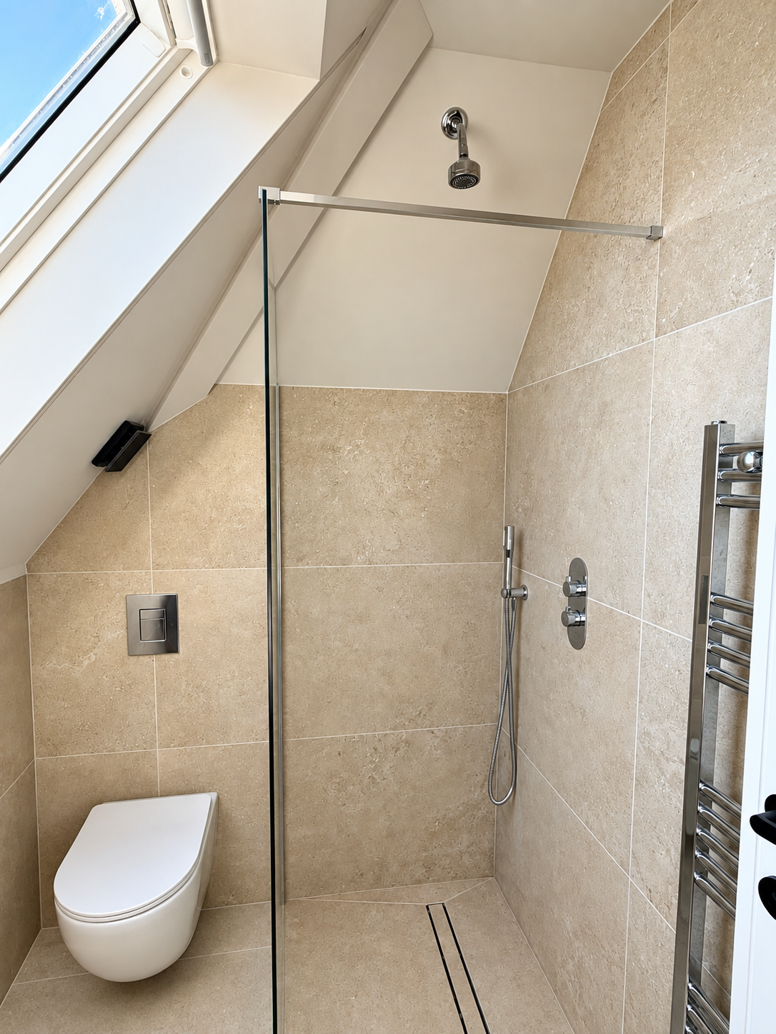 Loft bathroom with walk-in shower under the sloped roof