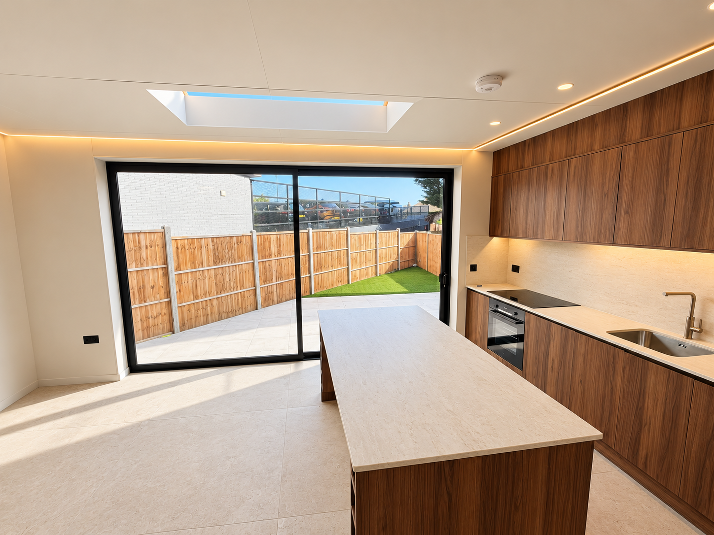 Walnut kitchen with island, rooflight and sliding doors to the garden
