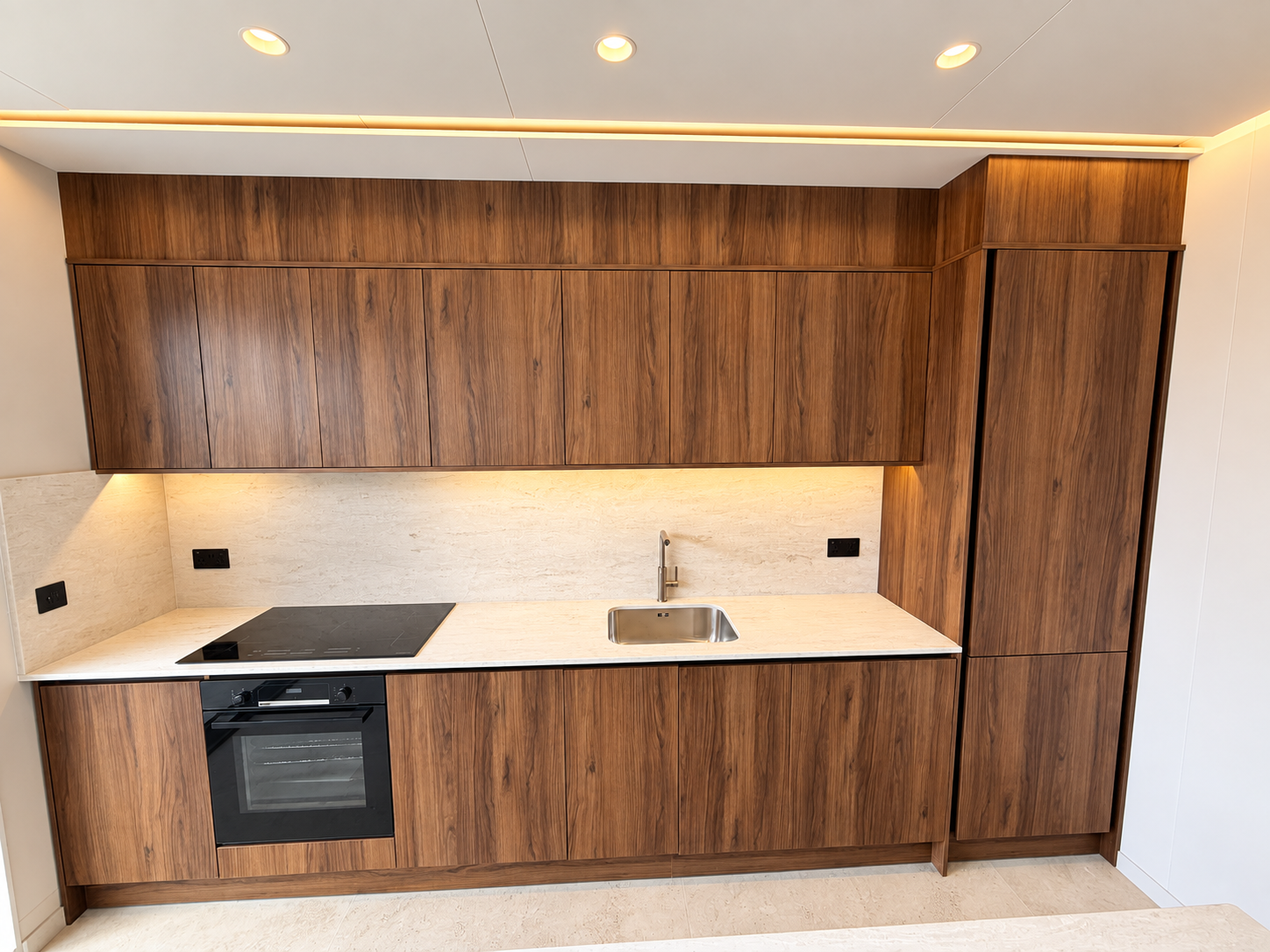 Walnut kitchen units with stone worktop and under-cabinet lighting