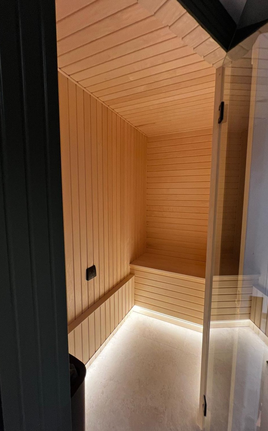 Sauna entrance with warm timber lining and under-bench lighting